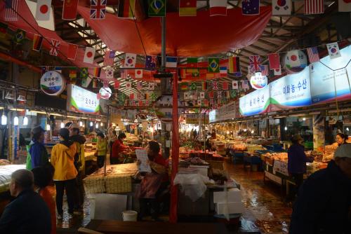 a market with people standing in a market with food at Jeju Stay Hotel in Jeju