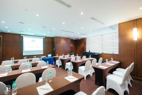 a conference room with tables and white chairs and a screen at City Garden Hotel Makati in Manila