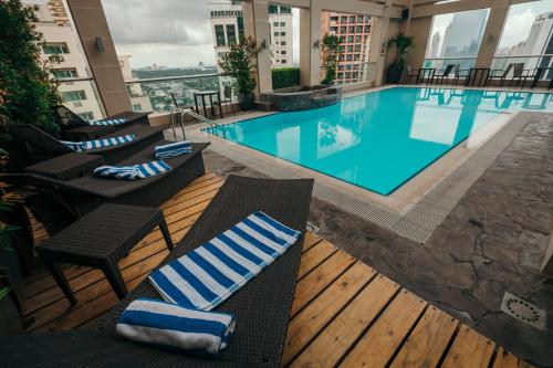 a swimming pool in a building with chairs at City Garden Hotel Makati in Manila