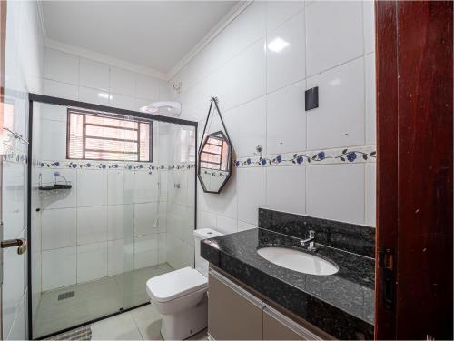 een badkamer met een wastafel en een toilet bij Piscina, Área Gourmet, Wi-fi e Garagem in Pirassununga