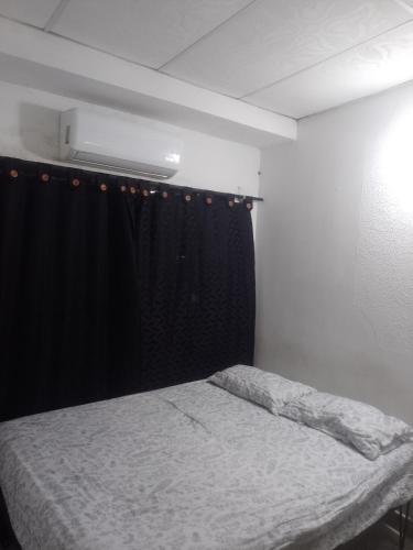 a bedroom with a bed and a black curtain at Apto central 3 hab in Apartadó