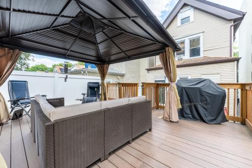 een patio met een bank en een parasol op een terras bij Massive NYC House with Pool Table in Yonkers