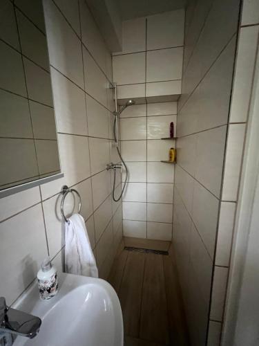 a white bathroom with a shower and a sink at Kleine Auszeit - Raum für Ruhe und neue Energie in Weidenberg