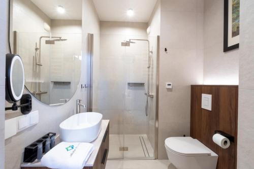a bathroom with a toilet sink and a shower at Laguna Beskidów Resort - Desert Spring in Zarzecze