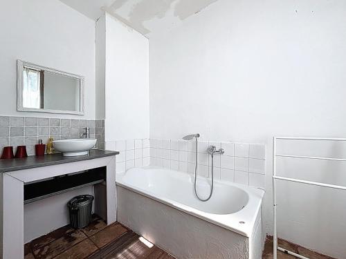 een witte badkamer met een bad en een wastafel bij Maison d'hôte Mas de Castille entre Uzès et le pont du Gard in Argilliers