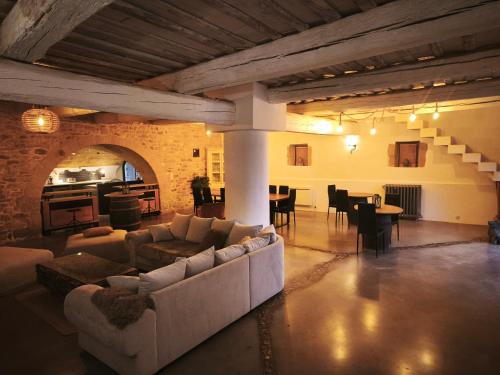 een grote woonkamer met banken en een eetkamer bij Maison d'hôte Mas de Castille entre Uzès et le pont du Gard in Argilliers