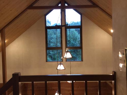 a room with a large window and two lights at Yamanakako Pension Pause in Yamanakako