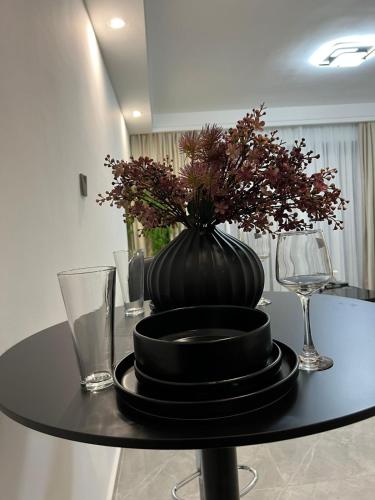 een zwarte vaas op een tafel met borden en glazen bij Polaris residency in Nairobi