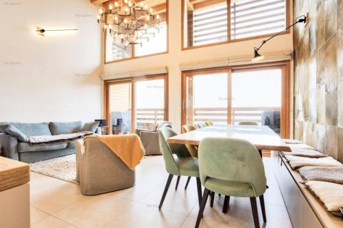 a dining room with a table and chairs at Résidence Alpine Loft - 5 Pièces 10 pers- HAUT DE GAMME - ALPINE LOFT - 10ALPI - PLAGNE CENTRE MAE-2634 in Aime-La Plagne
