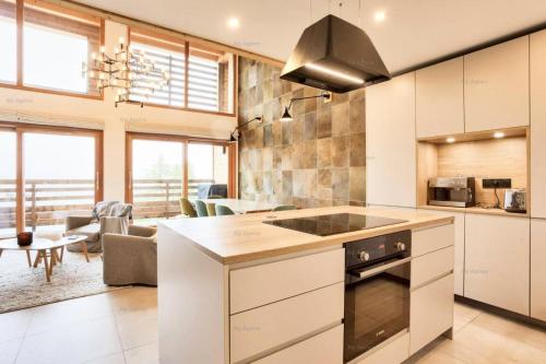 a kitchen with white cabinets and a stove at Résidence Alpine Loft - 5 Pièces 10 pers- HAUT DE GAMME - ALPINE LOFT - 10ALPI - PLAGNE CENTRE MAE-2634 in Aime-La Plagne