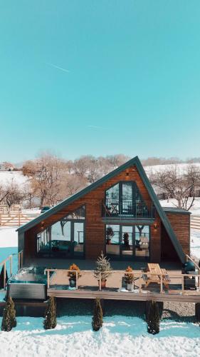 ein Haus im Schnee mit einer Terrasse in der Unterkunft Zenit Chalet-Bran in Sohodol