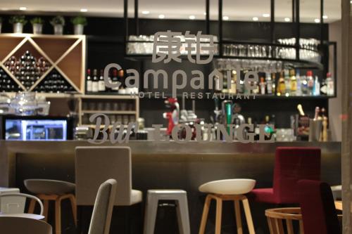 a restaurant with a bar with stools at Campanile Shanghai Bund Hotel in Shanghai