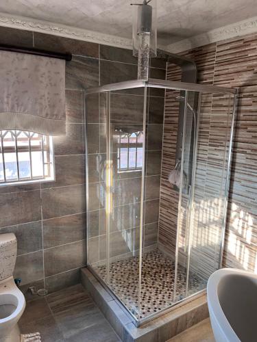 a bathroom with a shower with a toilet and a sink at Paradiso Palazzo in Welkom