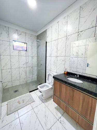 a bathroom with a toilet and a sink and a shower at A estrenar departamento en la mejor playa in Encarnación
