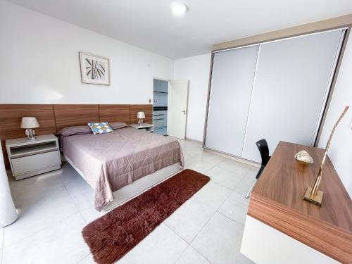 a bedroom with a bed and a desk and a table at A estrenar departamento en la mejor playa in Encarnación