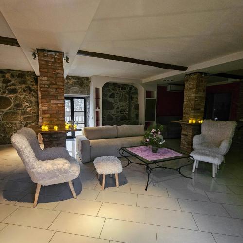 a living room with a couch and chairs and a table at Jauki Lauki in Lejasciems