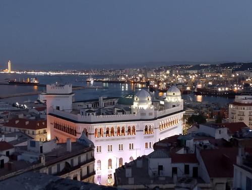 a large white building with a city at night at Appartement 3 pièces in LʼAgha