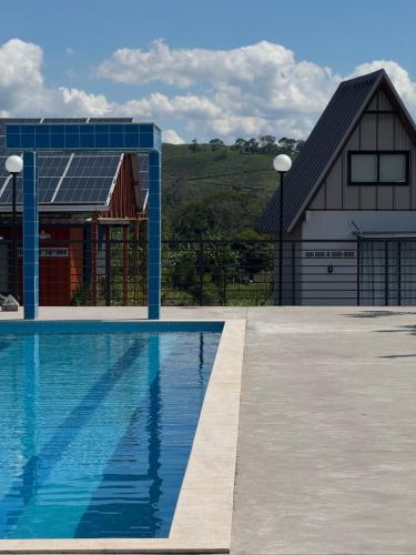 ein Swimmingpool vor einem Haus mit Scheune in der Unterkunft Pousada Aero Sofiste in Divino de São Lourenço