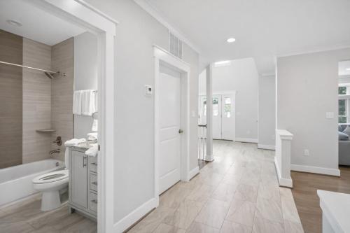 Un baño blanco con bañera y inodoro. en The Ultimate Luxury Home with Jacuzzi & Garage, en Falls Church
