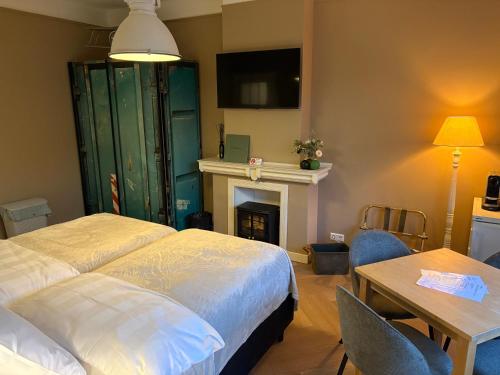 a bedroom with a bed and a table and a fireplace at Morelstraat in The Hague
