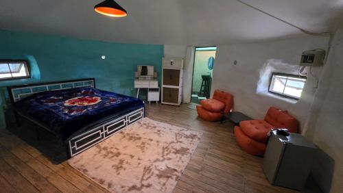 einen Blick über ein Schlafzimmer mit einem Bett und Stühlen in der Unterkunft OneSeasonFarm in Chiang Saen