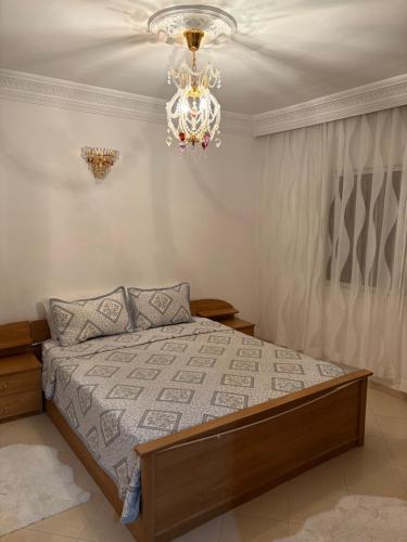 a bedroom with a bed and a chandelier at Harhoura stay in Temara
