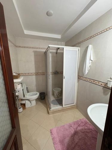 a bathroom with a shower and a toilet and a sink at Harhoura stay in Temara