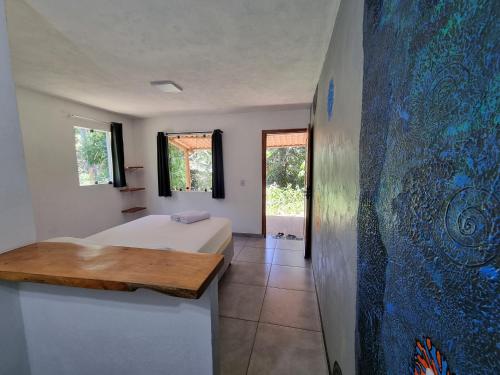 een slaapkamer met een bed en een schilderij aan de muur bij Suíte de Marcio in Itacaré