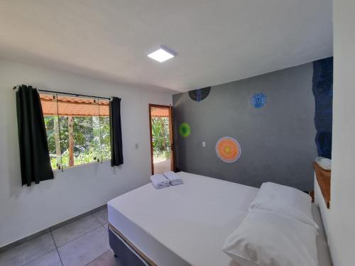 een slaapkamer met een wit bed en een raam bij Suíte de Marcio in Itacaré