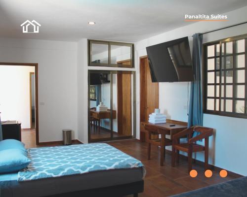 a bedroom with a bed and a table and a desk at PanaltitaSuites in Cancún
