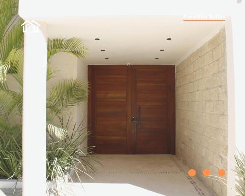 a wooden door in a hallway with plants at PanaltitaSuites in Cancún