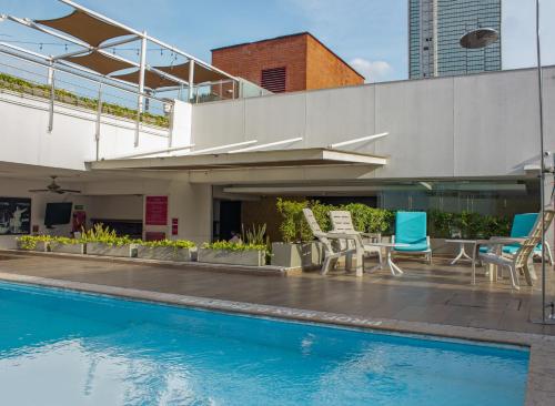 a patio with chairs and a swimming pool at Sonesta Hotel Cali in Cali