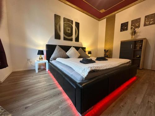 une chambre avec un grand lit et une lumière LED rouge dans l'établissement HONOR - Urban NEU RENOVIERT, à Linz