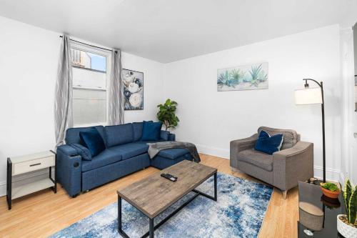 a living room with a blue couch and a chair at Urban 3BR Getaway Walk to ByWard Market- UOttawa in Ottawa