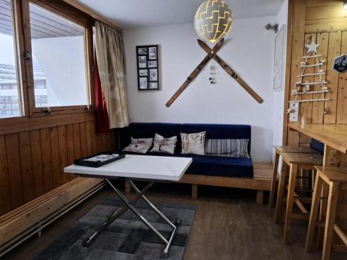 a living room with a blue couch and a table at Résidence Cachette - Superbe 2 pièces cabine 4 personnes à Arc 1600, proche des pistes et proche des commerces MAE-7831 in Arc 1600