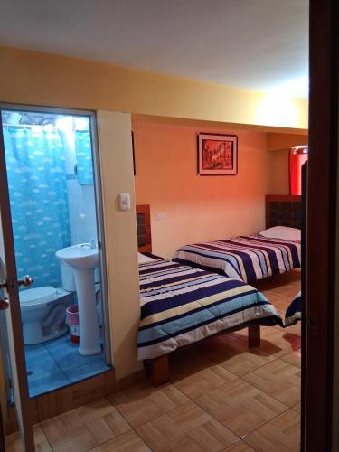 a bathroom with two beds and a sink at Hostal Kuntur Cusco in Cusco