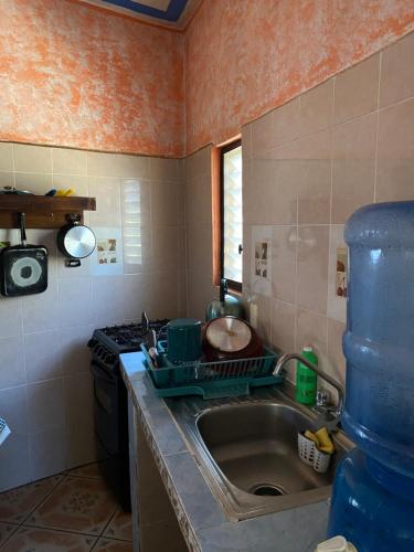 een kleine keuken met een spoelbak en een fornuis bij La Casita De Marlen in Puerto Ángel