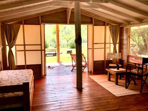 圣哈维尔Glamping Traslasierra Carpa Sur的客厅铺有木地板,设有玻璃门。