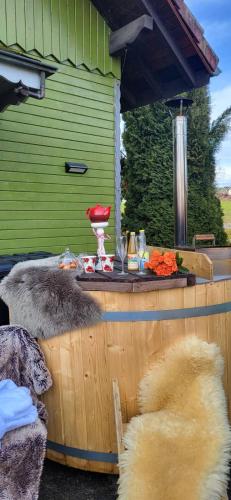 une terrasse avec une table et une serre dans l'établissement le chalet vert et bain nordique au feu de bois, à Frambouhans