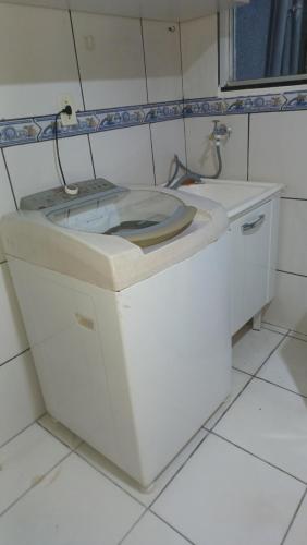 een wit toilet in een wit betegelde badkamer bij Sossego1 in Várzea Grande