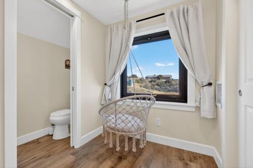 een rieten stoel in een badkamer met een raam bij Mountain View • Fire Pit + Hammock • Loft & Office in Humboldt