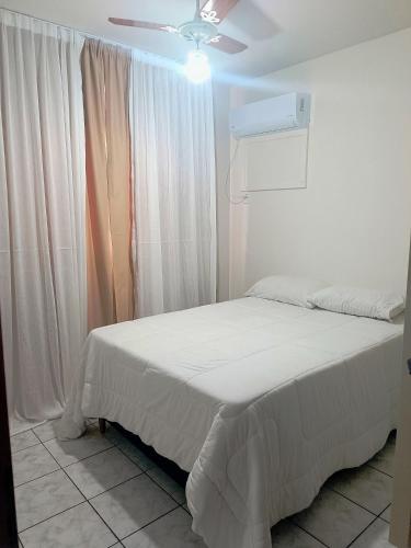 a bedroom with a bed and a ceiling fan at Quarto no centro de Foz do Iguaçu in Foz do Iguaçu