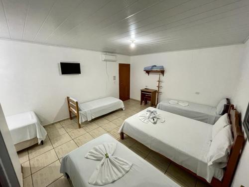 a hotel room with two beds and a tv at Estância Hotel in Jardim