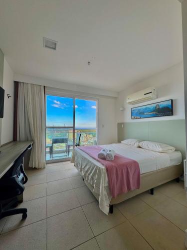 a bedroom with a bed and a large window at Vista Mar no 16º Andar e Smart TV in Macaé