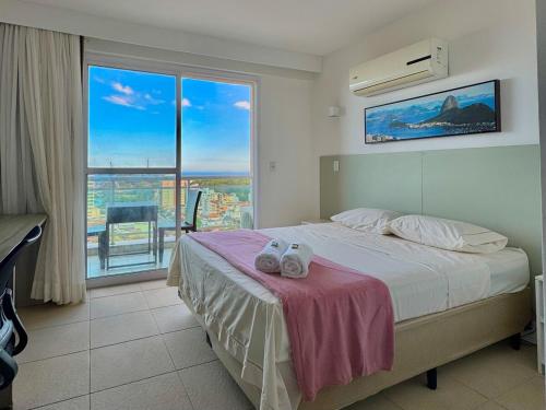 ein Schlafzimmer mit einem Bett und einem großen Fenster in der Unterkunft 16º andar com vista pro mar in Macaé