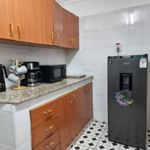 een keuken met een zwarte koelkast en een magnetron bij Nadreya Nakuru Milimani Suite in Nakuru
