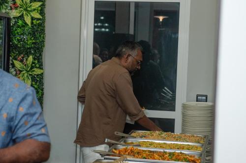 a man standing next to a buffet of food at Reagal Garden in Hulhumale