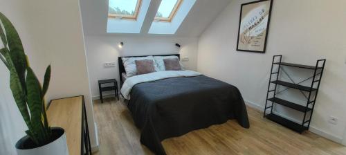 a bedroom with a bed and a plant in it at Wilga House 1 in Piła
