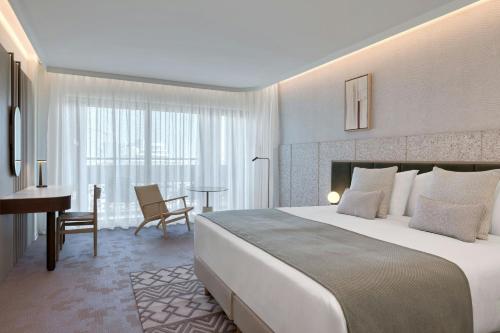 a hotel room with a large bed and a desk at The Landmark Nicosia, Autograph Collection in Nicosia