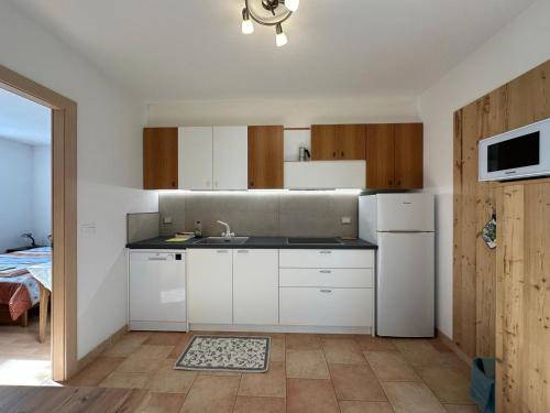 una cucina con mobili bianchi e un lavandino di Appartamenti LITEGOSA casa vacanza 2 a Panchia